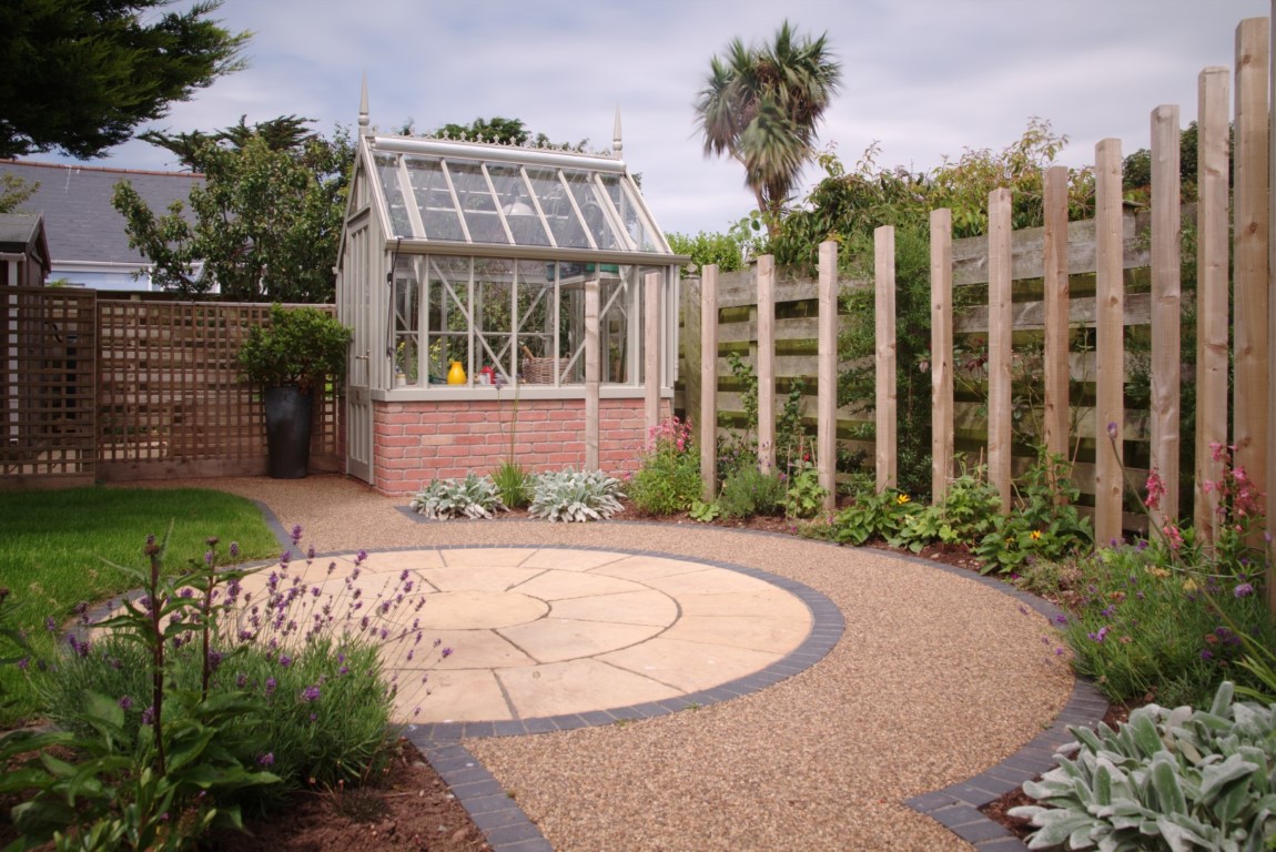 Circular paving with pathway and curved timber feature surrounded by planting